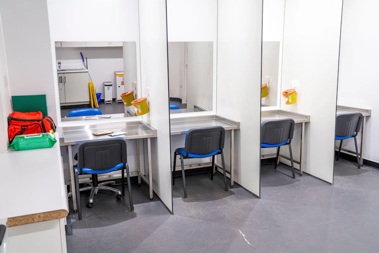 Drug consumption room with chairs and sharps bins.