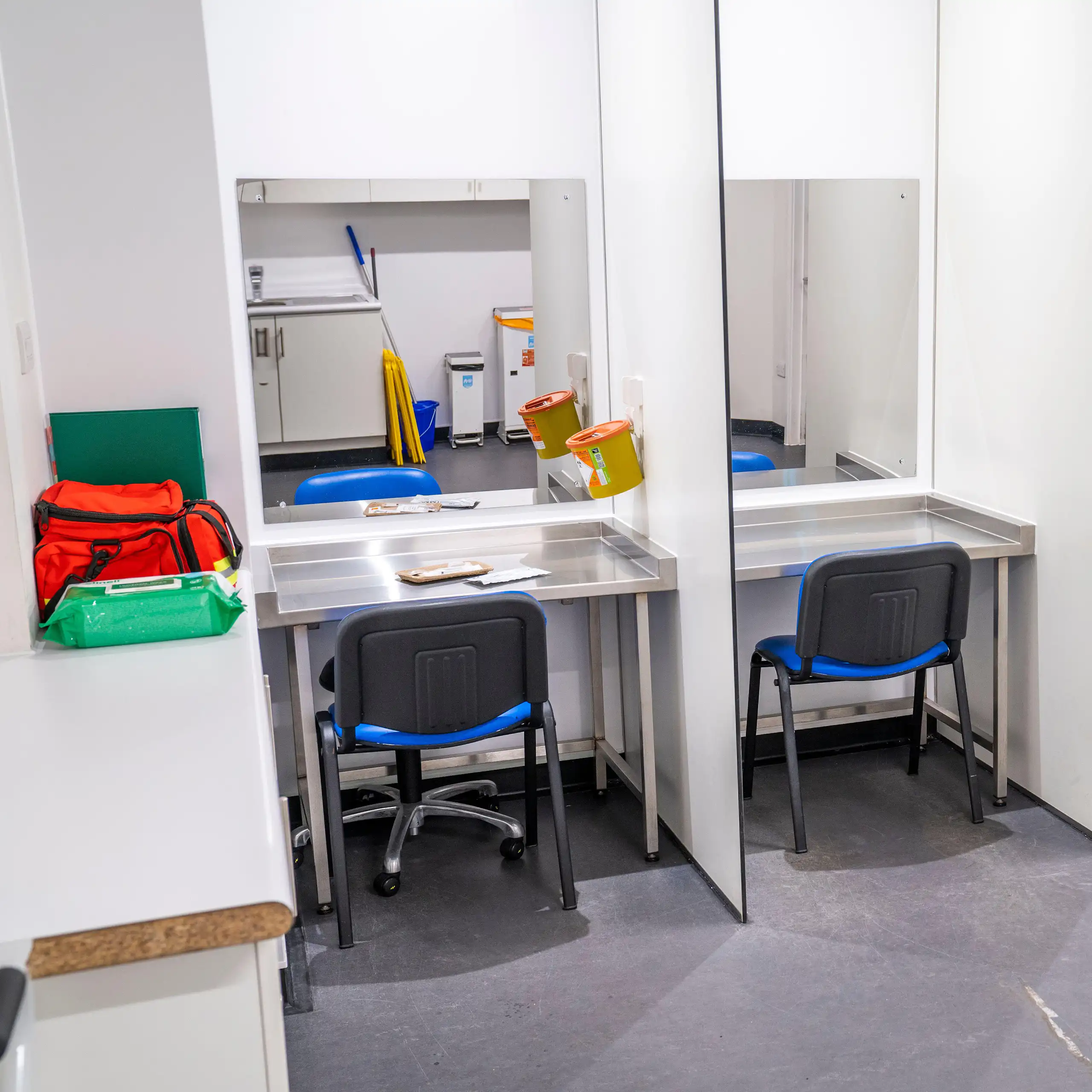 Drug consumption room with chairs and sharps bins.