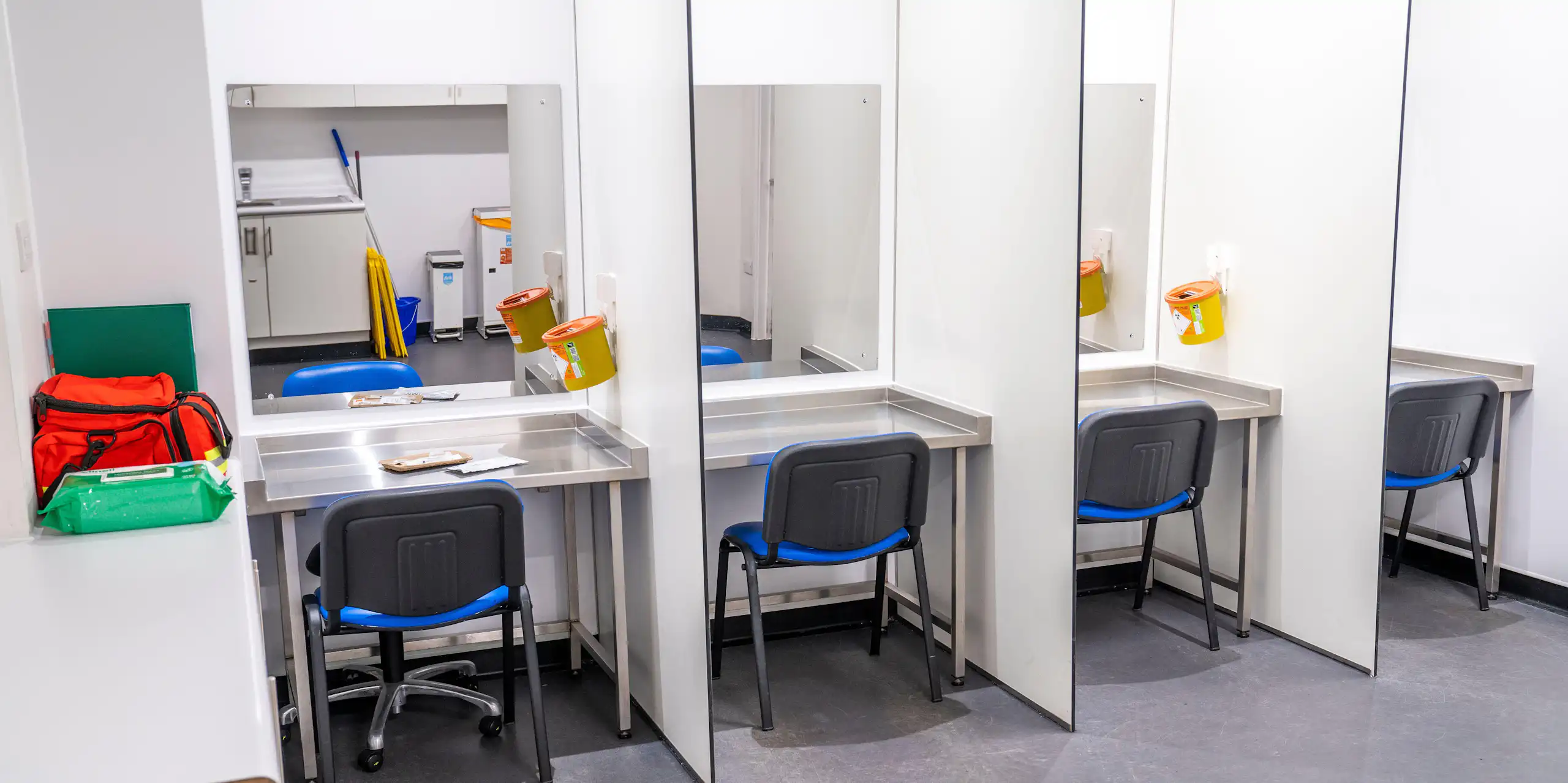 Drug consumption room with chairs and sharps bins.