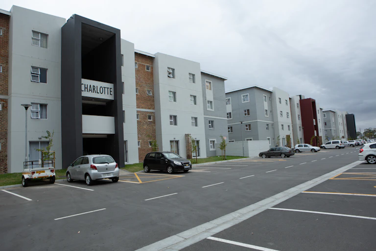 A block of flats with a large parking lot