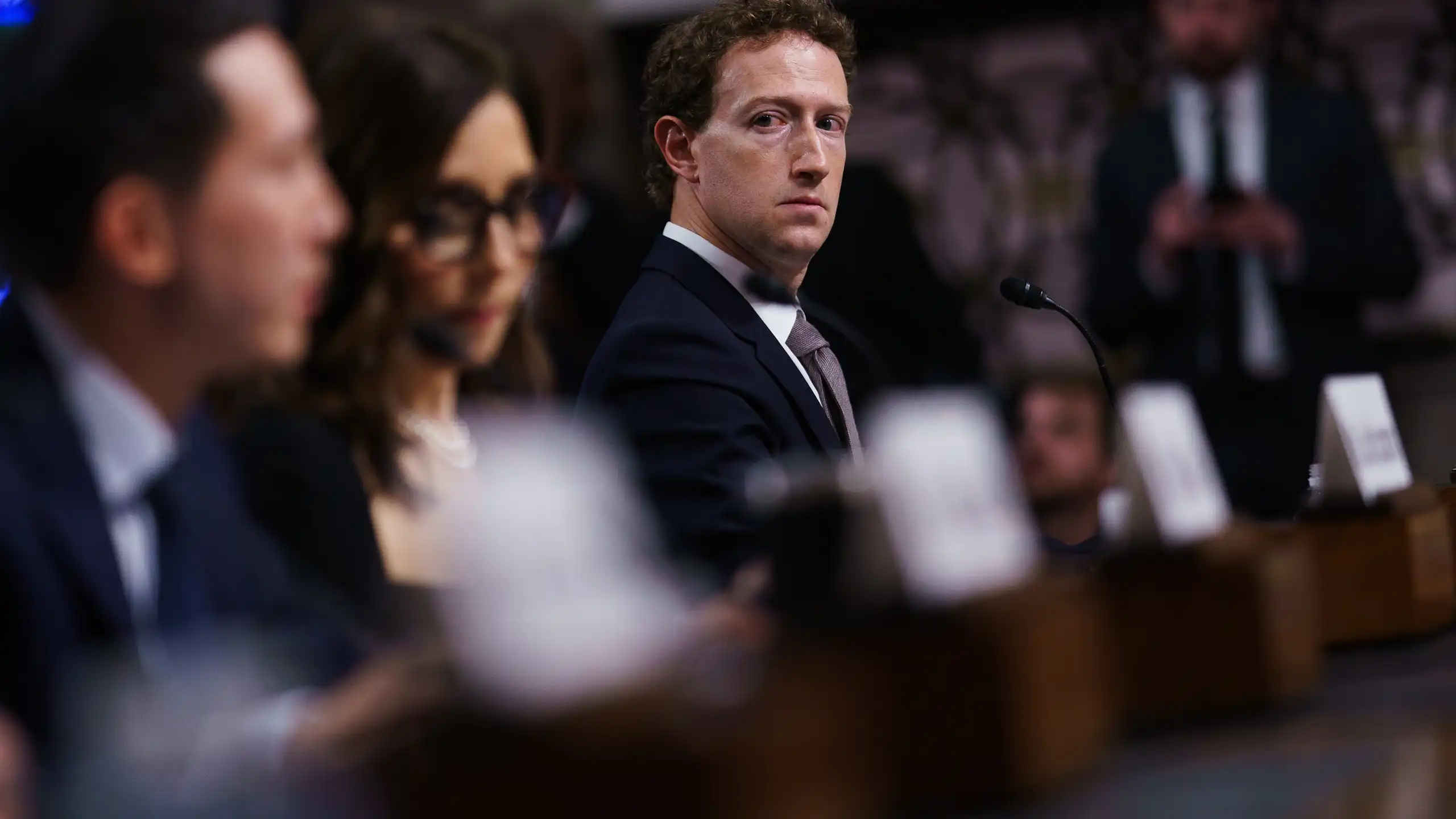 Mark zuckerberg looking solemn, sitting beside other tech executives in the Senate