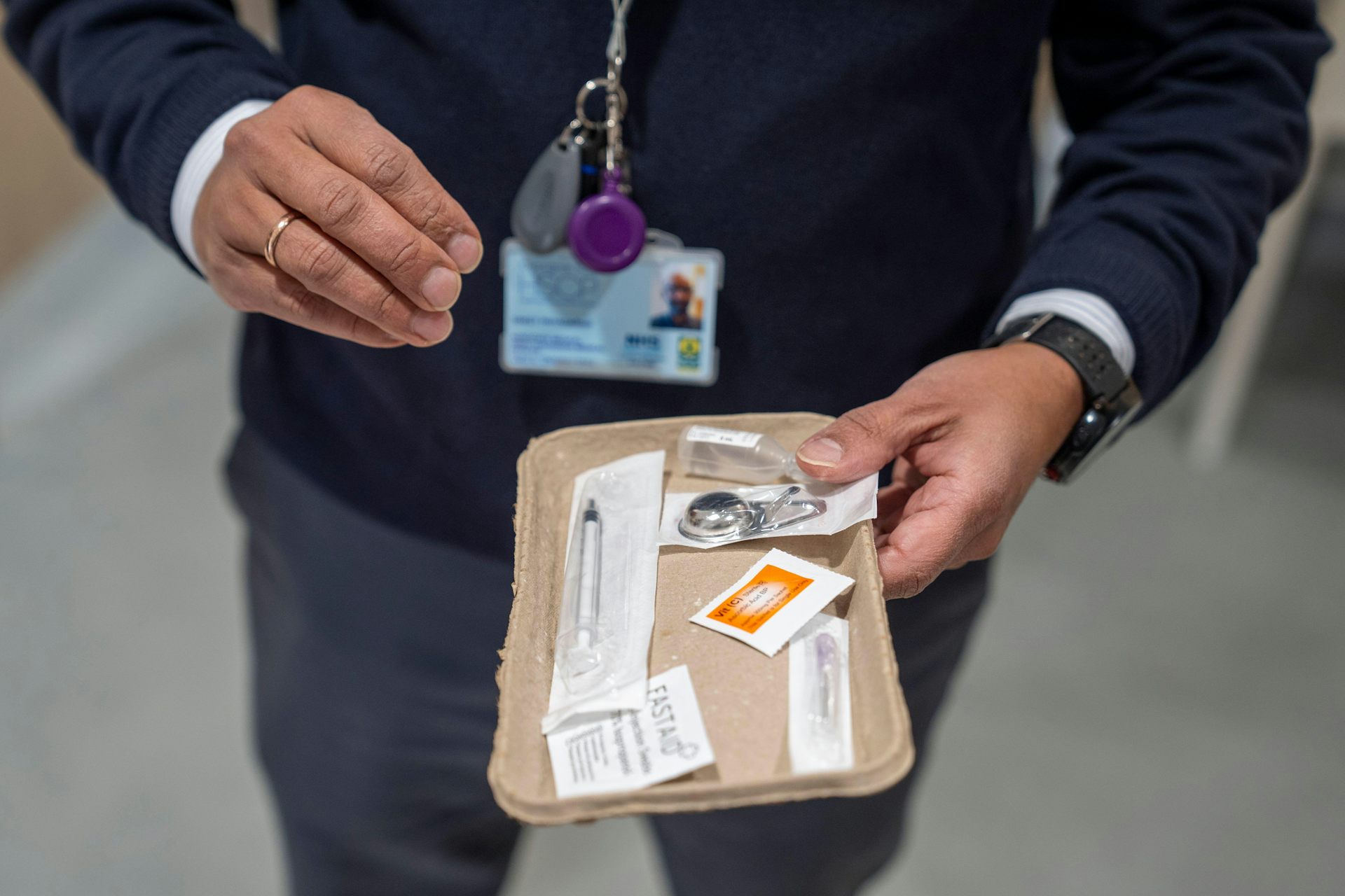 A person holds a drug injection kit for the camera.