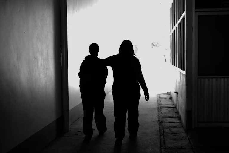 Two women walking silhouetted