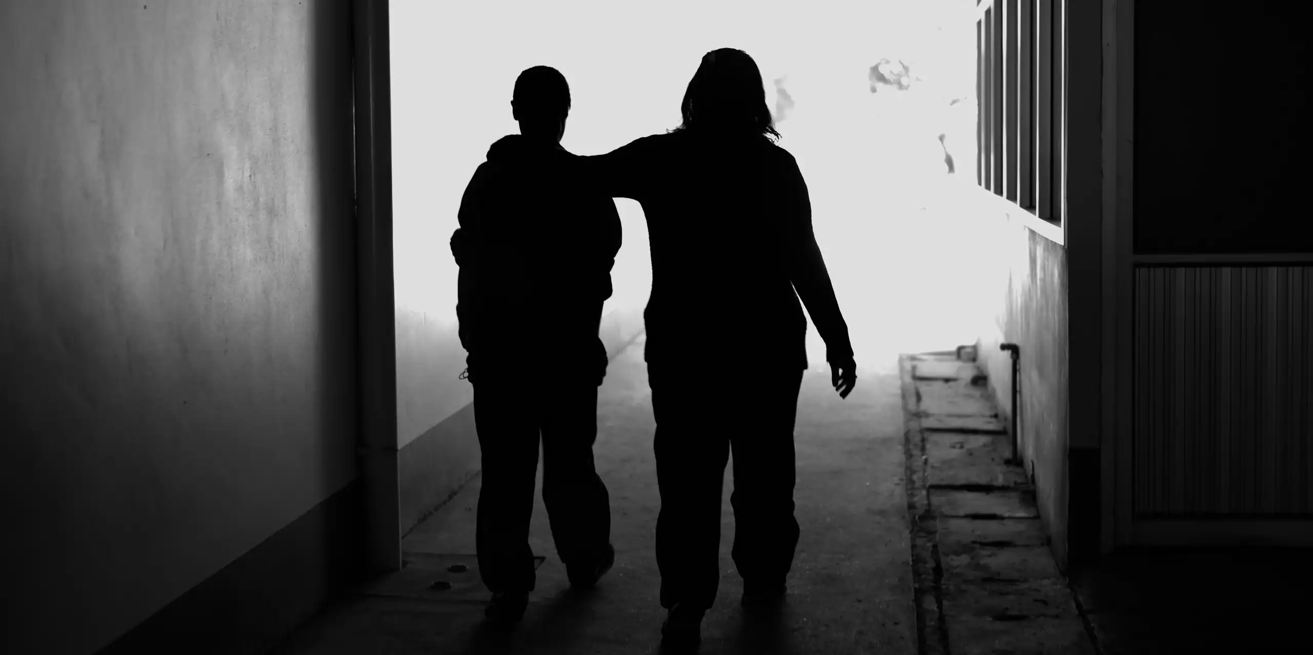 Two women walking silhouetted