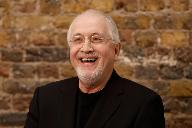 Patrick Doyle laughing in a black suit.
