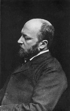 Photographic profile portrait of bald middle-aged man with a beard.