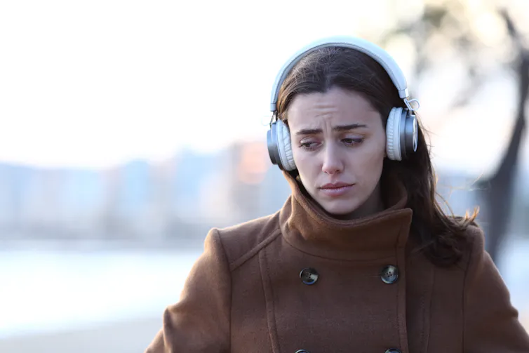 A sad woman with headphones.