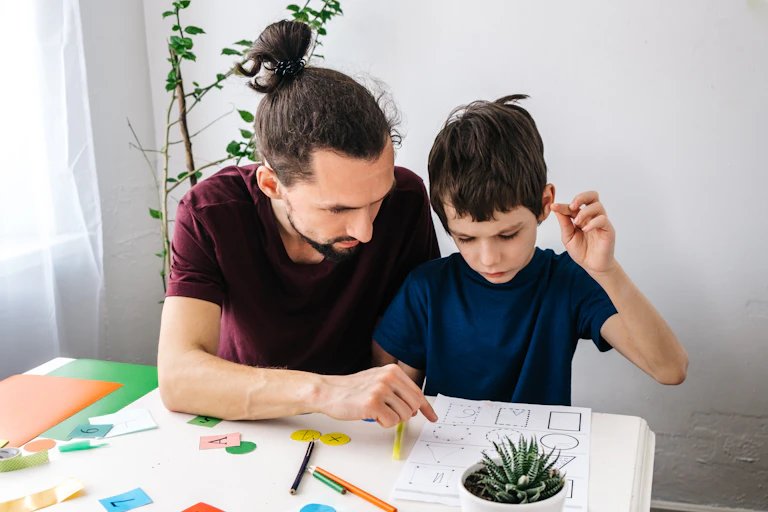 Teacher points to a worksheet an autistic boy is reviewing