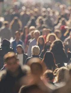 Crowd of people walking city street