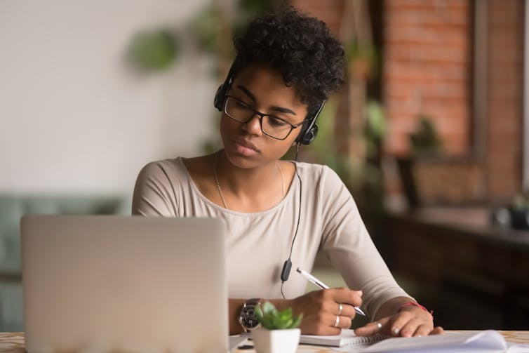 Woman works while wearing headphones