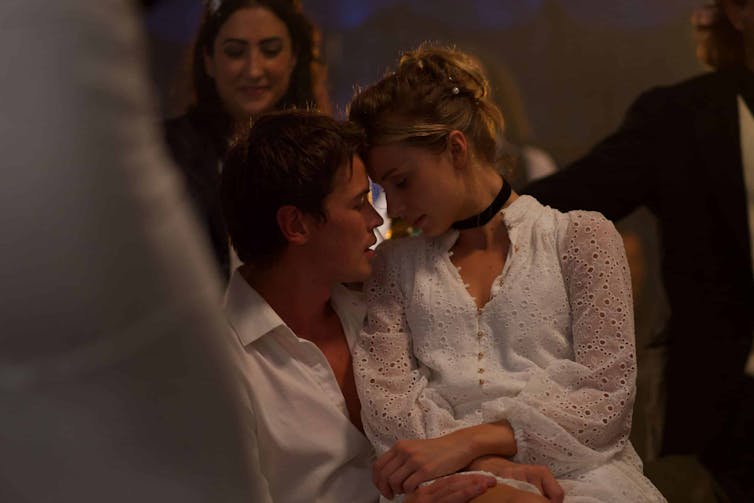 A young man and woman embrace.