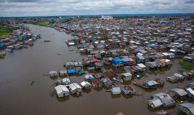 An aerial view of Iquitos showing boats and structures in a vast river.