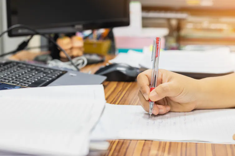 Un enseignant corrige des copies