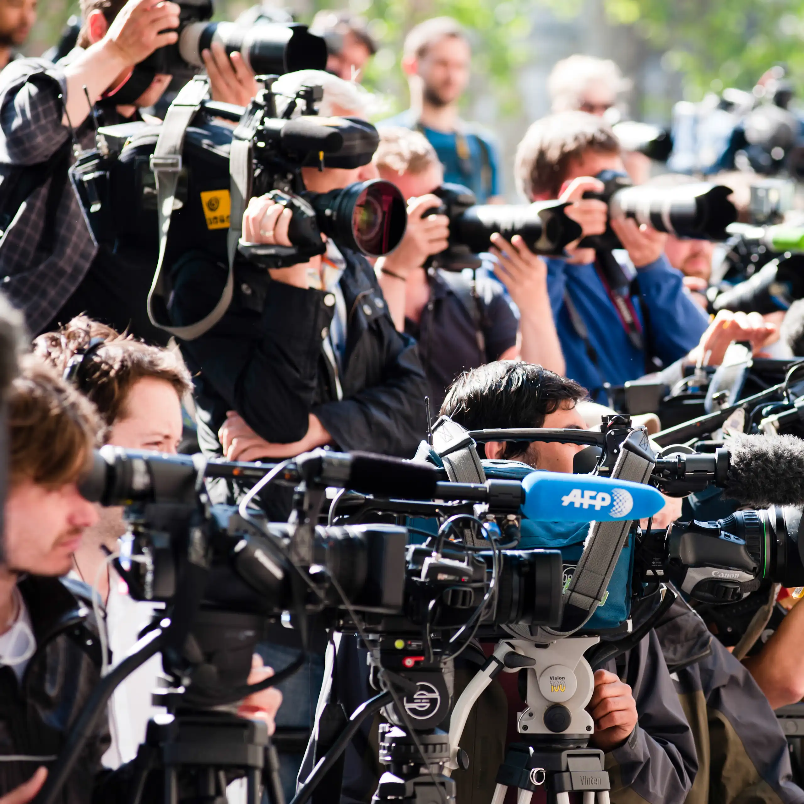A crowd of reporters with cameras and microphones