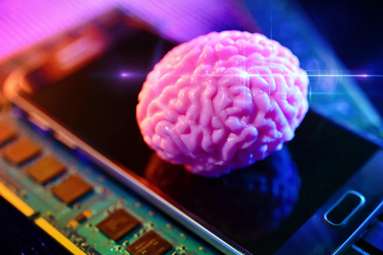 A pink brain on a smartphone with computer board.