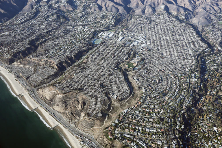 Hundreds of burned homes on a plateau along the Pacific coast