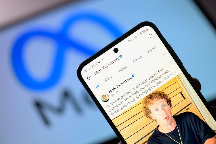 Mark Zuckerberg personal Facebook account is displayed on a mobile phone with Meta logo seen on tablet screen behind.