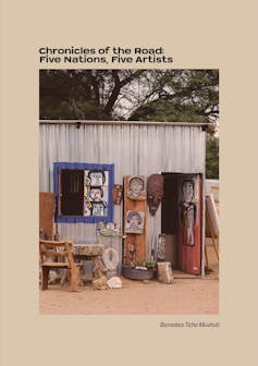 A book cover with a beige background and a photo of a tin shack with a red door, blue window and artworks displayed in front, portraits, and a large chair.