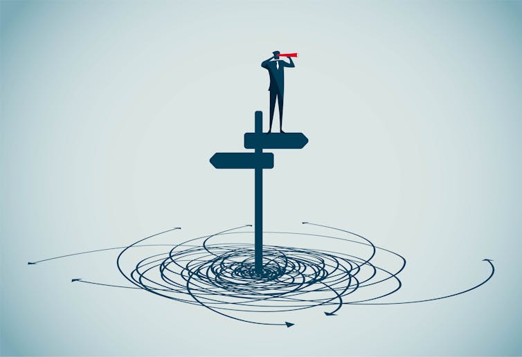 A person standing on a signpost with two arrows, surrounded by confusing arrows on the ground.