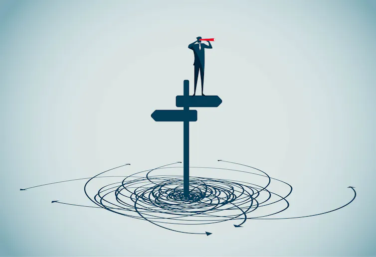 A person standing on a signpost with two arrows, surrounded by confusing arrows on the ground.