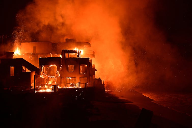 A house burning down with huge flames.