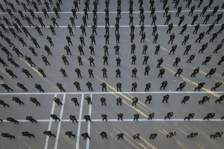 Rows of police recruits photographed from above.
