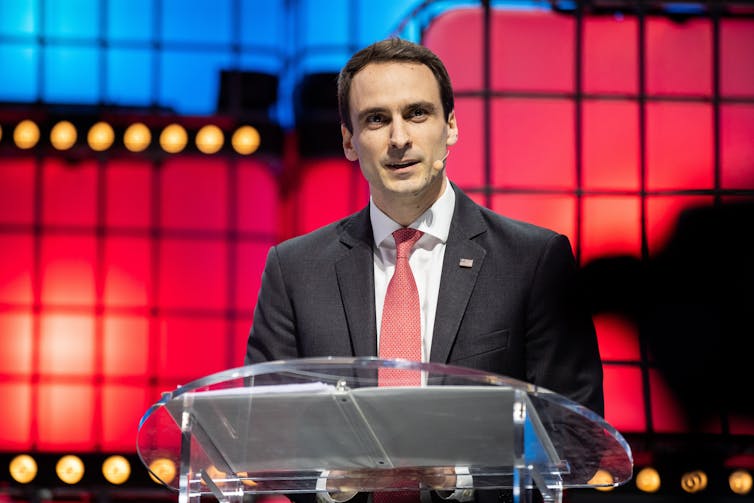 man standing at podium against colorful display background