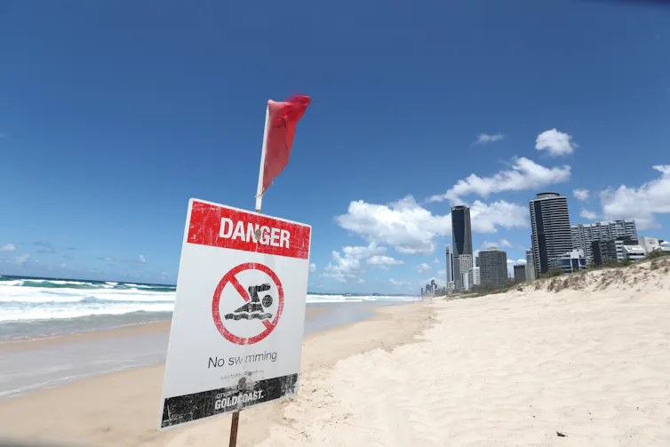 sign on beach reading 'Danger: no swimming'
