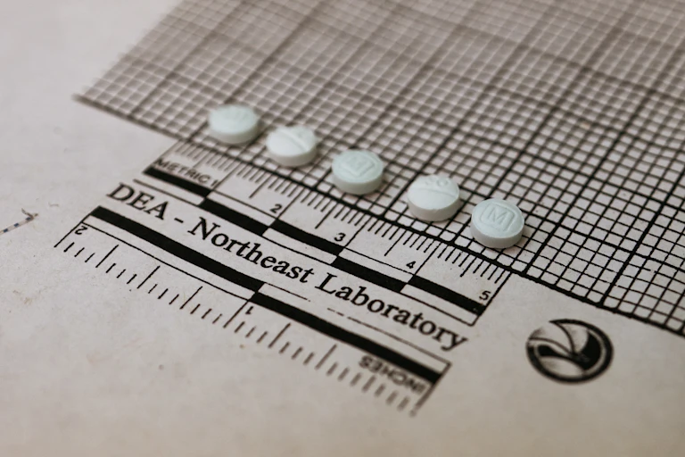 Suspected fentanyl tablets are placed on a graph to measure their size at a Drug Enforcement Administration laboratory on Oct. 8, 2019.