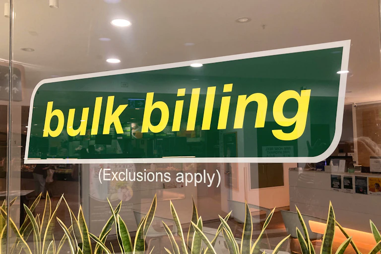 Sign on a clinic window reading "bulk billing: exclusions apply".