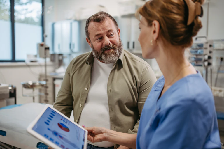 A medical professional talking to an overweight patient.