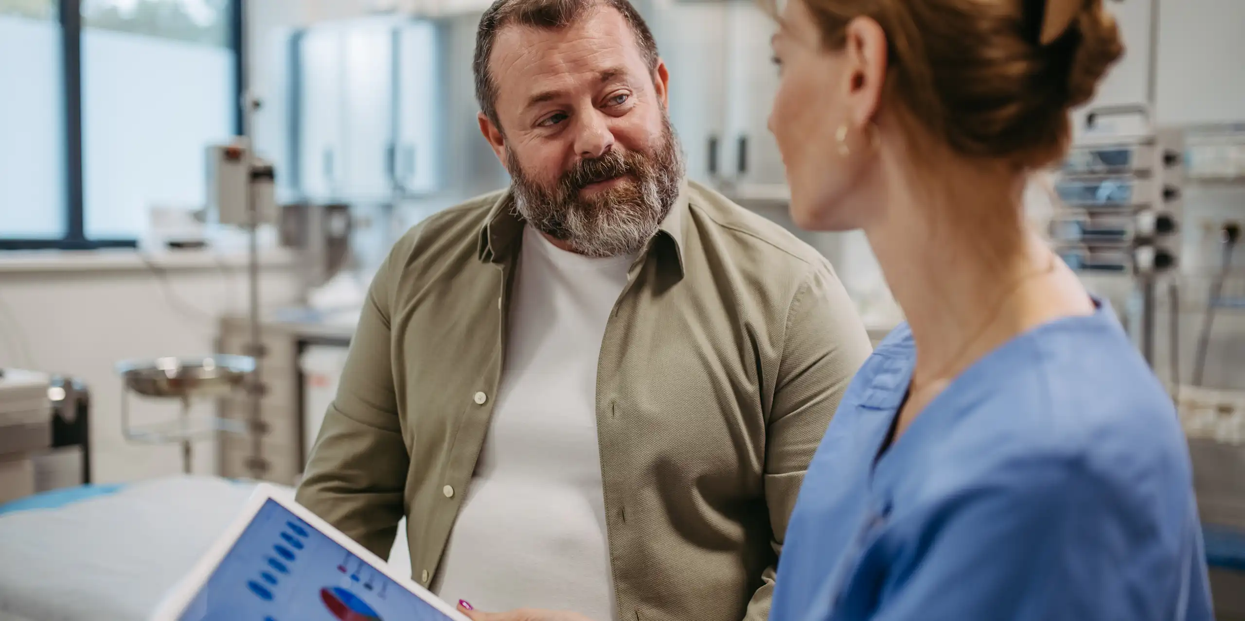 A medical professional talking to an overweight patient.
