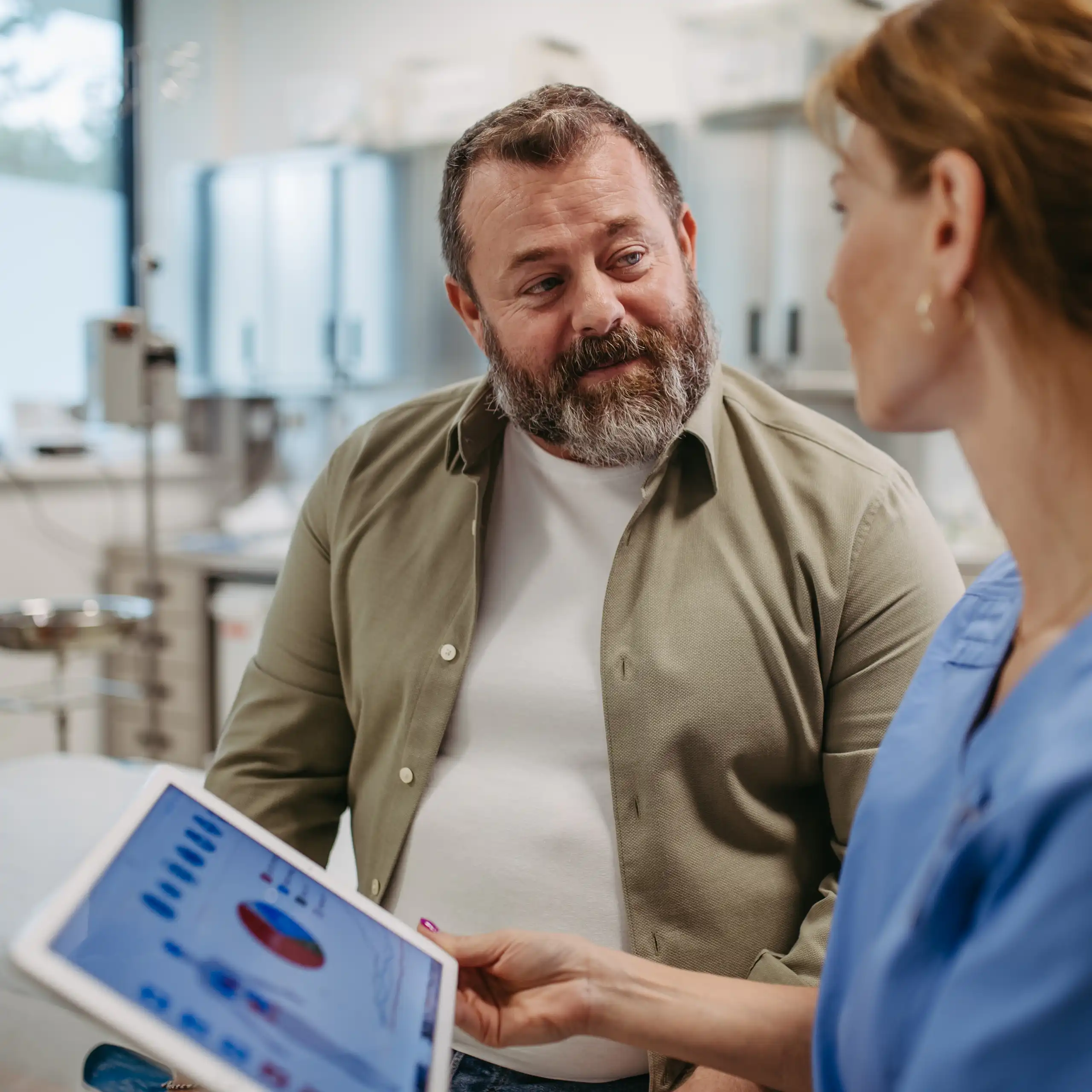 A medical professional talking to an overweight patient.