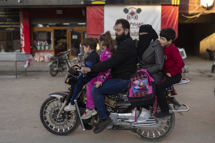 Une famille à moto dans une rue d’Idlib, en Syrie, le 14 janvier 2025