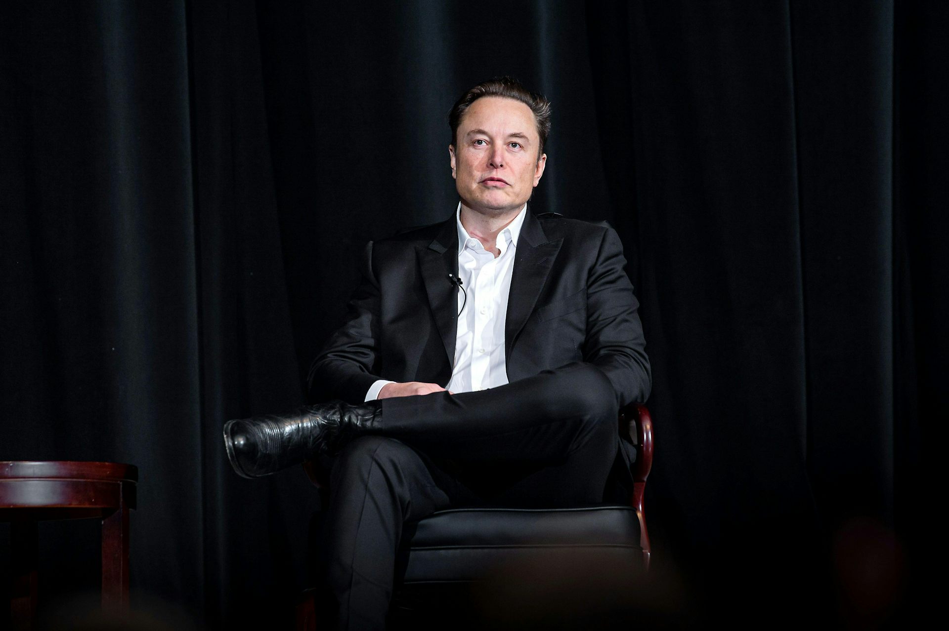 Elon Musk sitting in a chair.