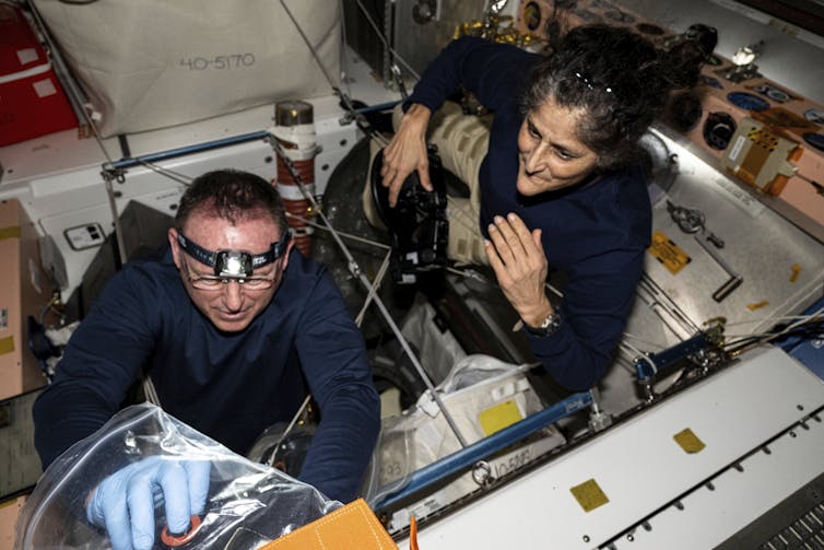 Astronauts Butch Wilmore and Suni Williams inspecting safety hardware aboard the International Space Station