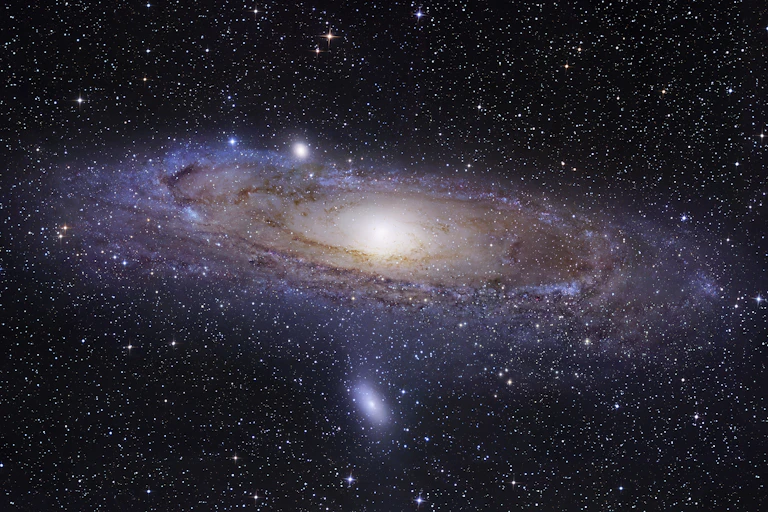 A galaxy, with a bright spot in the center and gas and dust swirling around it.