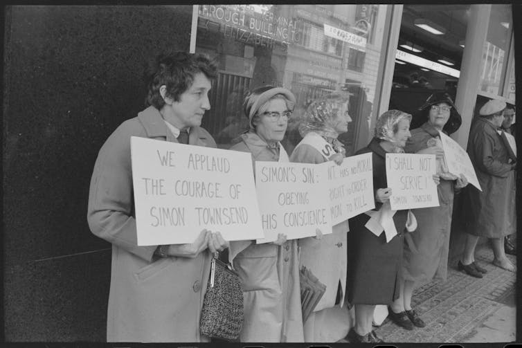 Older women hold signs in support.