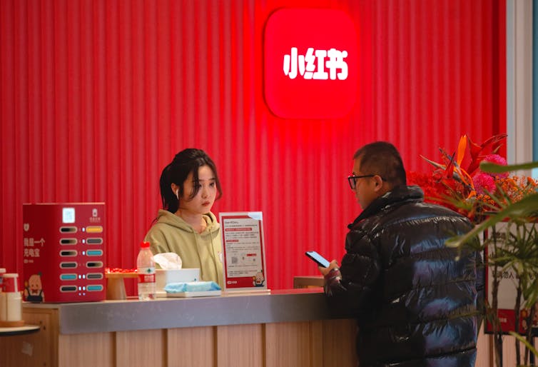 A receptionist stands behind a desk at the RedNote company headquarters.