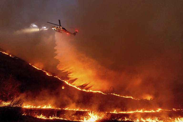 A helicopter flying over the fires in LA.