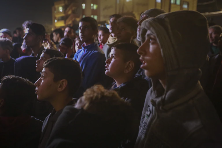 A group of Palestinians watch a TV