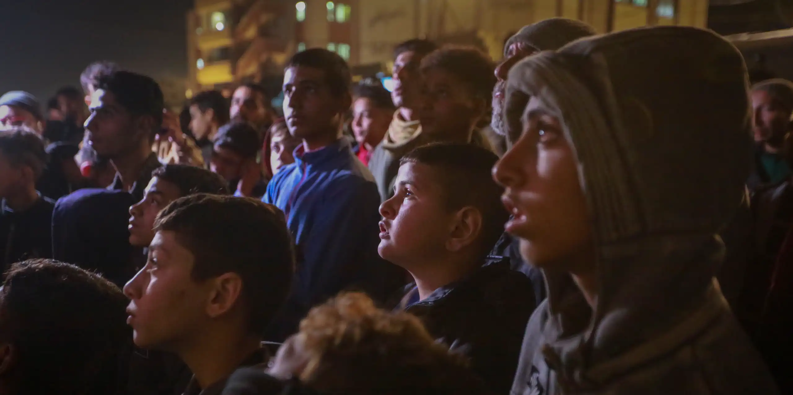 A group of Palestinians watch a TV