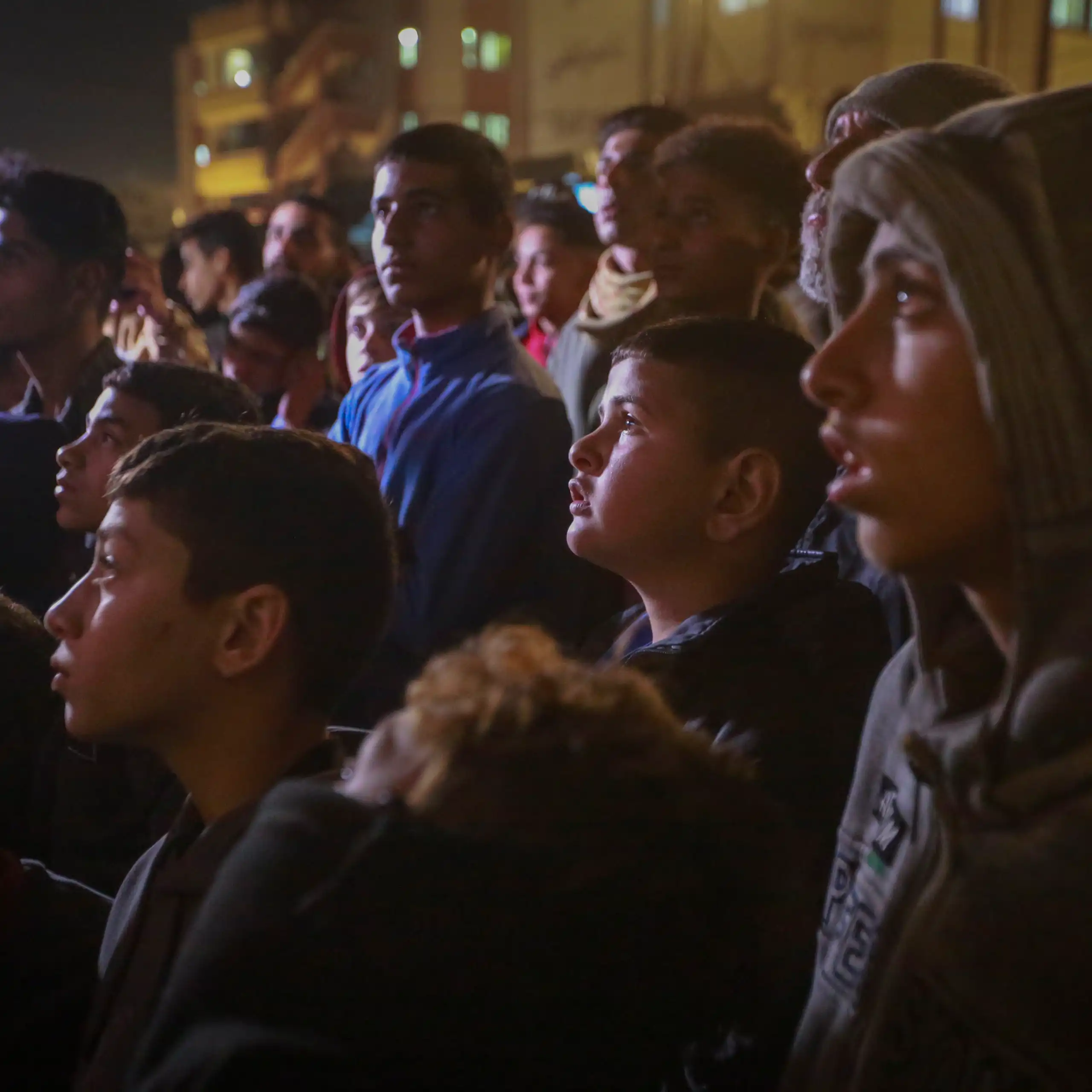 A group of Palestinians watch a TV