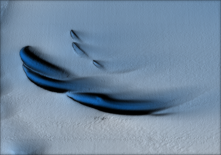 Streak of dark blue ice on a white ice sheet.