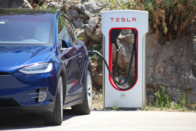 A parked blue car being recharged.