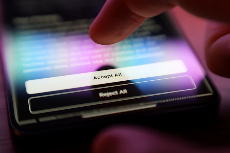 Finger about to press 'Accept All Cookies' button on a privacy policy.