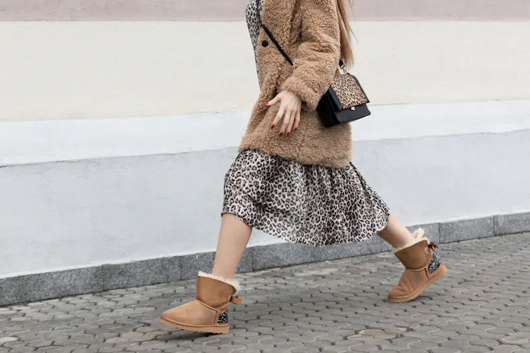 A woman walks in uggs.