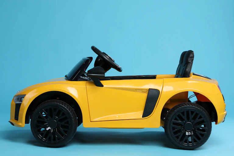 small child's yellow electric car, blue background
