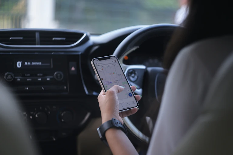 main qui tient un smartphone dans une voiture