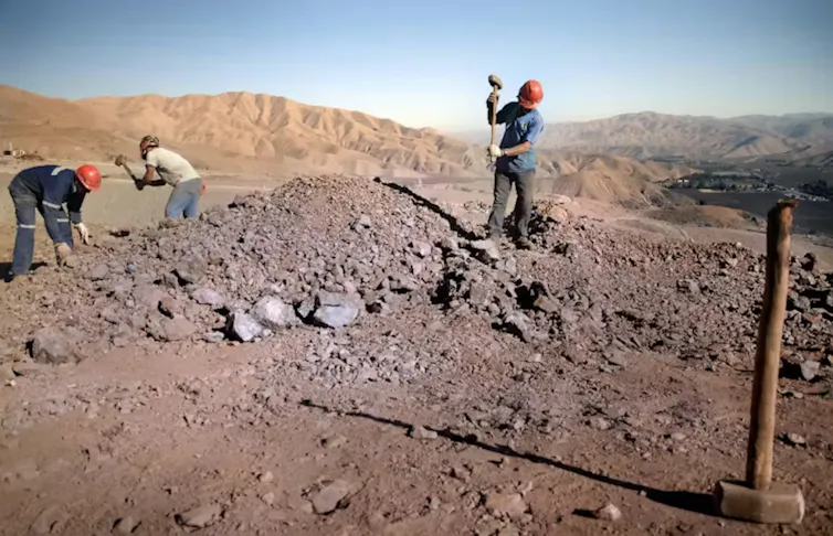 trois hommes travaillent dans une mine